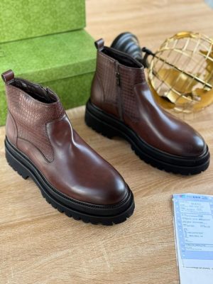 Brown Gucci leather Chelsea boots with chunky black sole and textured side panel displayed with green box and receipt.