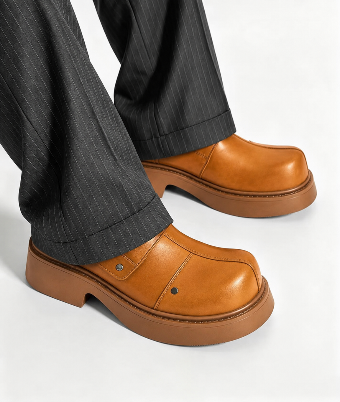 Premium leather monk-strap loafers Men's luxury leather monk-strap loafers with chunky black platform soles and silver hardware accents being held by hand next to white trousers.