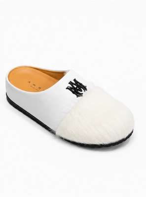 AMIRI luxury fur slide mules in white, black, and brown with authentic leather upper, plush fur detailing, signature AM logo, and cushioned sole displayed with original black AMIRI box