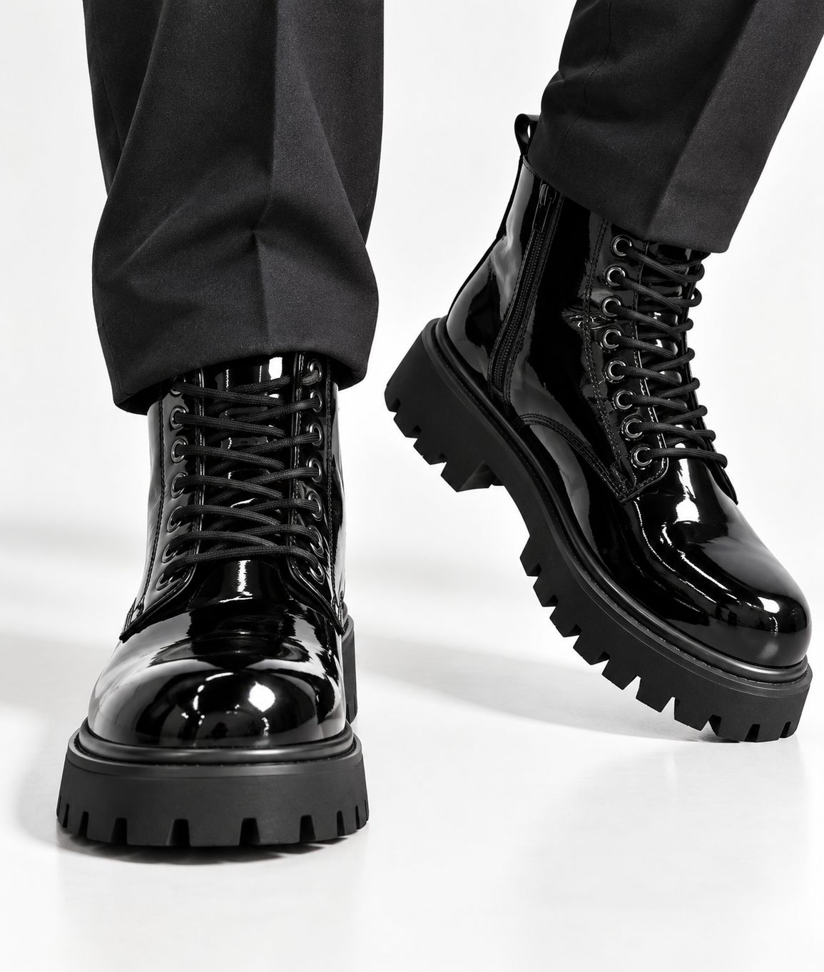 Black FDCR patent leather combat boots with chunky lug sole displayed with blue FDCR boxes.
