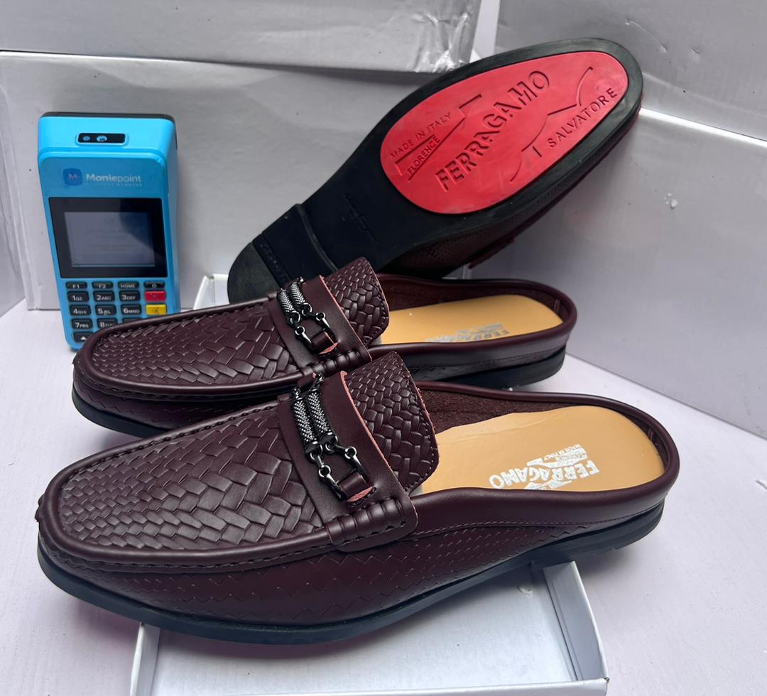 Salvatore Ferragamo Men’s Gancini Bit Loafer Salvatore Ferragamo brown perforated leather loafer with Gancini bit buckle, held by hand showcasing craftsmanship