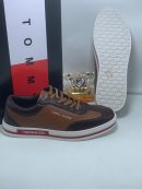 Brown and tan Tommy Hilfiger leather sneakers with white sole and red stripe detail - luxury men's casual shoes.