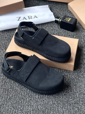Black Zara leather sandals with velcro strap and ankle buckle displayed with Zara packaging on grey carpet