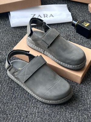Black Zara leather sandals with velcro strap and ankle buckle displayed with Zara packaging on grey carpet