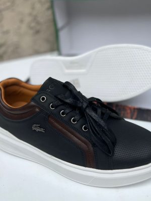 Black Lacoste leather sneakers with brown accents and white sole displayed with shoe box.