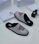 Silver crystal-embellished Versace slides with red Medusa head logo and black sole displayed with Versace packaging and 24K perfume.