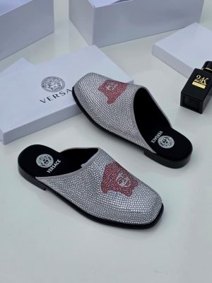 Silver crystal-embellished Versace slides with red Medusa head logo and black sole displayed with Versace packaging and 24K perfume.