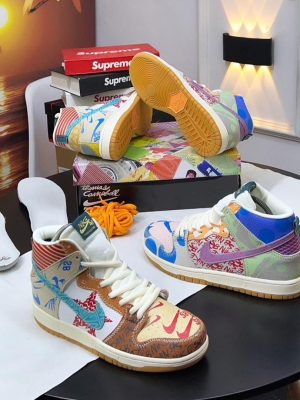 Multi-colored Nike SB Dunk High What The P-Rod sneakers with patchwork design and gum sole displayed with Thomas Campbell art box and extra laces.