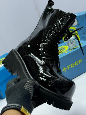 Black FDCR patent leather combat boots with chunky lug sole displayed with blue FDCR boxes.