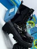 Black FDCR patent leather combat boots with chunky lug sole displayed with blue FDCR boxes.