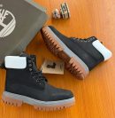 Black Timberland premium boots with white collar flap and chunky gum sole displayed with branded box and tag.
