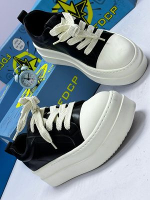FDCP men's black and white chunky platform sneakers with oversized toe cap and thick rope laces, displayed with blue branded shoebox and vintage alarm clock on white surface.