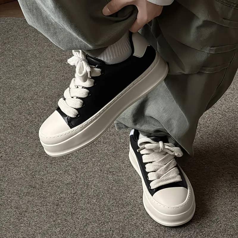 FDCP chunky platform sneakers FDCP men's black and white chunky platform sneakers with oversized toe cap and thick rope laces, displayed with blue branded shoebox and vintage alarm clock on white surface.