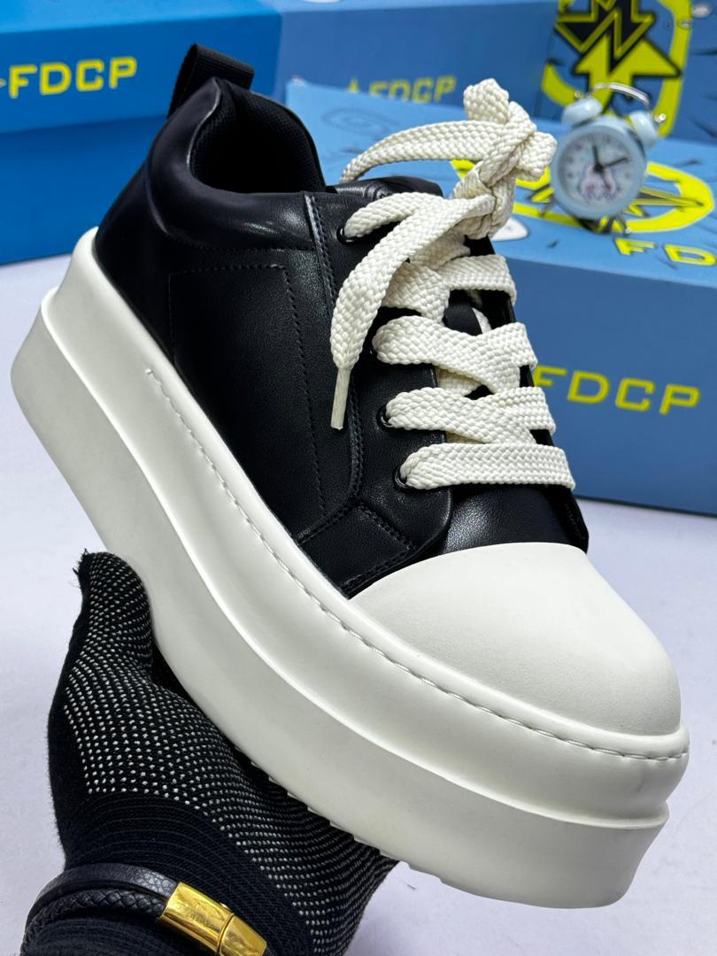 FDCP chunky platform sneakers FDCP men's black and white chunky platform sneakers with oversized toe cap and thick rope laces, displayed with blue branded shoebox and vintage alarm clock on white surface.