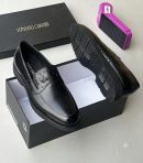 Men's black Roberto Cavalli high-gloss leather penny loafers with quilted vamp detail and ridged sole, displayed in a branded black shoebox.