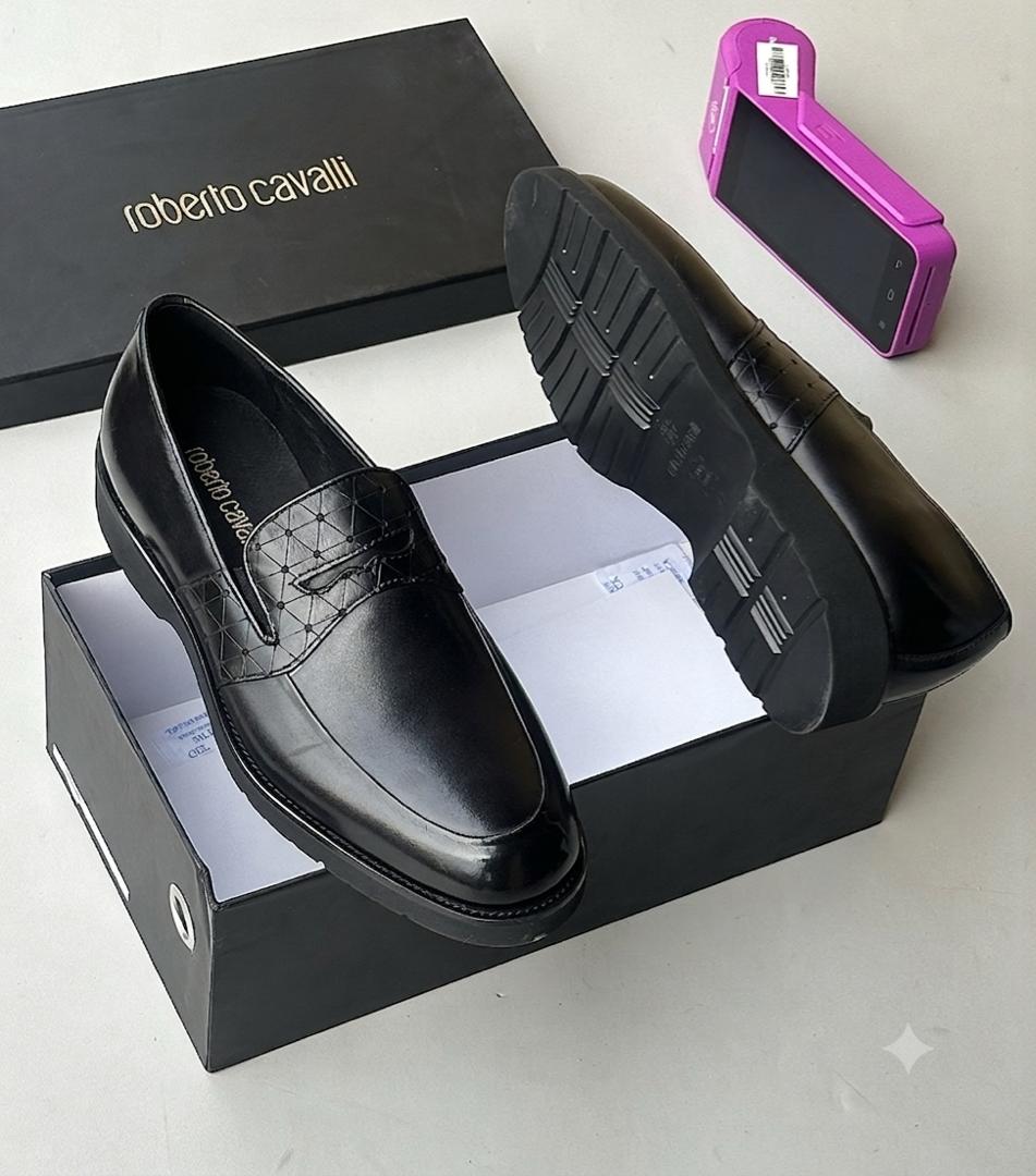 Roberto Cavalli black high-gloss leather loafers Men's black Roberto Cavalli high-gloss leather penny loafers with quilted vamp detail and ridged sole, displayed in a branded black shoebox.