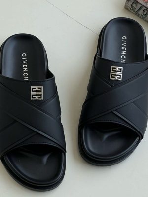A pair of men's luxury black leather slides and a pair of grey leather slides, displayed on a wooden surface with premium packaging, showcasing their sleek design and premium material.