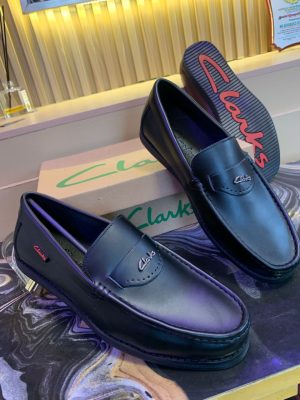 Black leather Clarks penny loafers with embossed logo strap - premium men's dress shoes with classic design