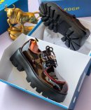 Black patent leather derby shoes with chunky black lug sole and gold hardware - luxury men's formal shoes with high-gloss finish