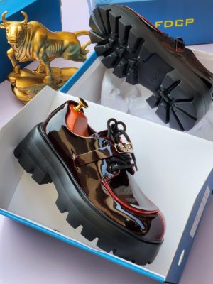 Black patent leather derby shoes with chunky black lug sole and gold hardware - luxury men's formal shoes with high-gloss finish