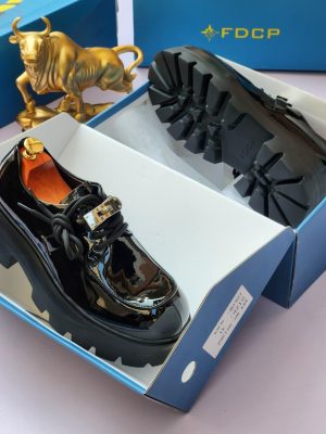 Black patent leather derby shoes with chunky black lug sole and gold hardware - luxury men's formal shoes with high-gloss finish