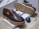 Brown Lacoste leather loafers with embossed crocodile texture, metal horsebit hardware, and chunky tan platform sole displayed with white Lacoste boxes