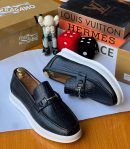 Black crocodile-embossed leather loafers with horsebit metal hardware and white platform sole displayed with luxury brand boxes