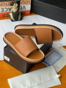 Tan Valentino Garavani leather slides with embossed VLOGO, Rockstud detailing, and white contrast stitching displayed with black box and dust bag