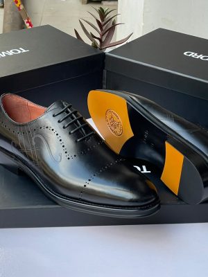 Brown men's burnished leather Tomford oxford shoes with violin engraving and brogue detailing.