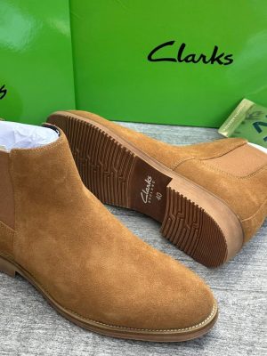 Tan Clarks suede Chelsea boots with ridged rubber sole displayed with green Clarks box.