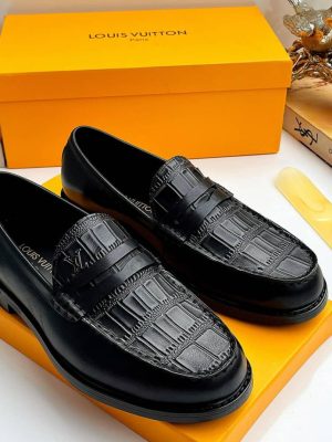 Black Louis Vuitton leather loafers with crocodile embossed vamp and heel chain hardware displayed with orange LV box and bird decor.