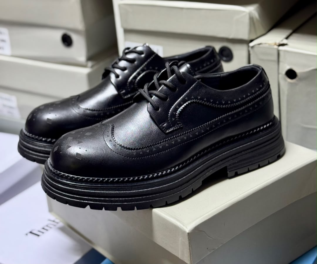 Premium cognac leather brogues Men's luxury cognac brown leather brogue oxford shoes with geometric toe cap detailing and thick black ridged sole sitting on white shoeboxes.