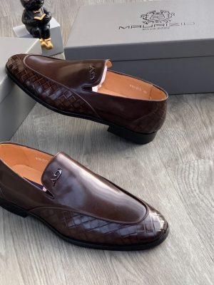 Men's chocolate brown Maurizidio woven leather loafers with metallic logo and black rubber sole, displayed on grey wood floor with branded shoebox.