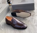 Men's chocolate brown Maurizidio woven leather loafers with metallic logo and black rubber sole, displayed on grey wood floor with branded shoebox.