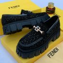 Black men's Fendi platform loafers with geometric textured upper, metallic FF hardware, and chunky rubber lug sole.