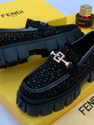 Black men's Fendi platform loafers with geometric textured upper, metallic FF hardware, and chunky rubber lug sole.