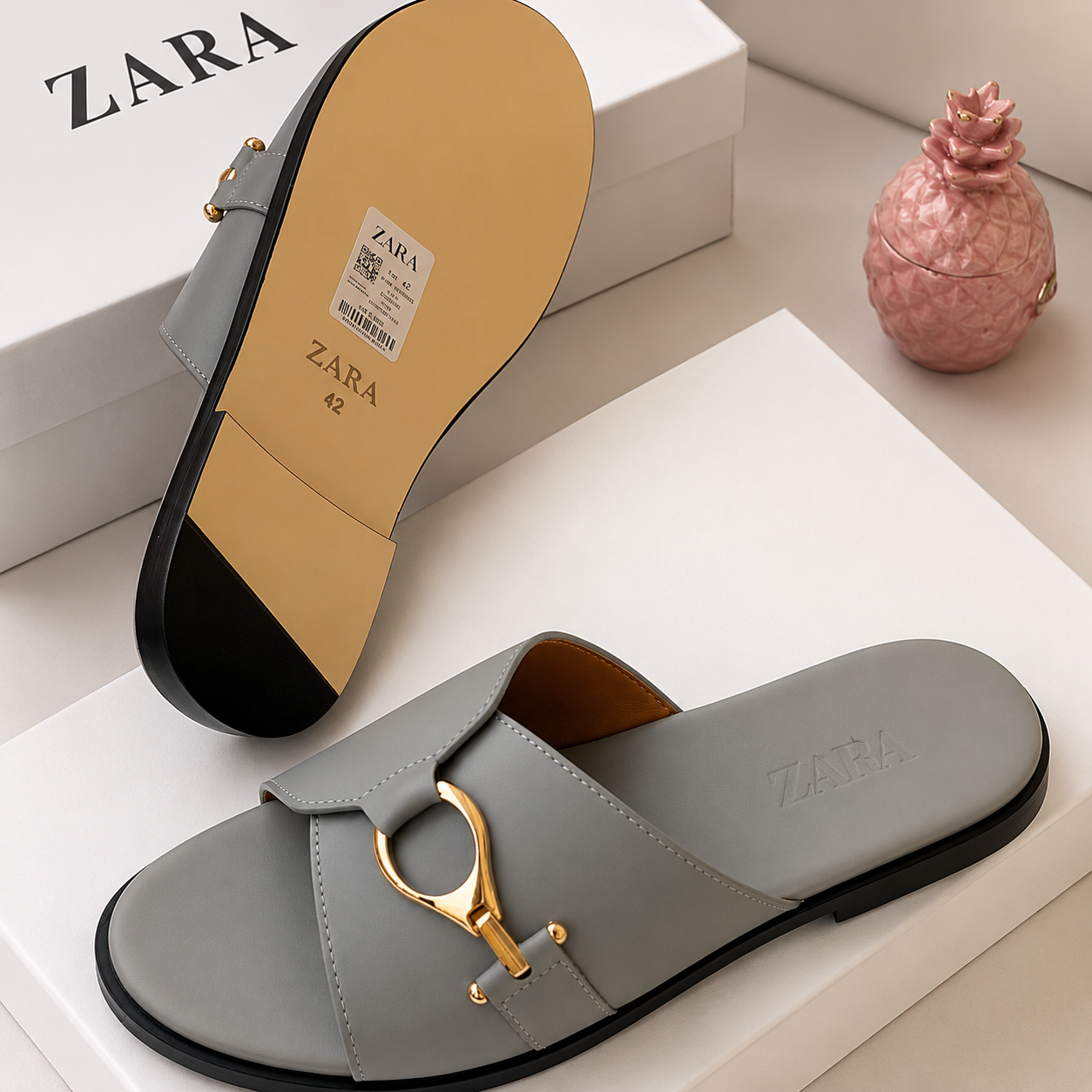 Authentic Zara horsebit slide sandals Zara men's slide sandals in black and grey with gold horsebit buckle hardware, displayed with white Zara shoebox and dust bag on dark slatted surface.