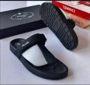 Black Prada leather thong sandals with adjustable ankle strap and chunky geometric tread sole displayed with Prada box.