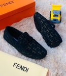 Black Fendi FF monogram driving loafers with rubber sole displayed on fluffy rug with orange Fendi box and toy truck.