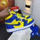 Brown and orange Nike Air Jordan 1 High sneakers with cream base and extra laces displayed with Nike box.