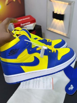 Brown and orange Nike Air Jordan 1 High sneakers with cream base and extra laces displayed with Nike box.