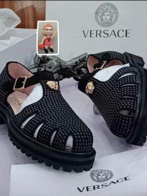 Versace men's black leather fisherman sandals with gold Medusa buckle and chunky black rubber lug sole, displayed with white Versace box, dust bag, and authenticity card.