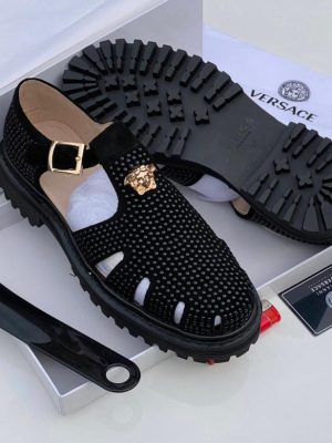 Versace men's black leather fisherman sandals with gold Medusa buckle and chunky black rubber lug sole, displayed with white Versace box, dust bag, and authenticity card.