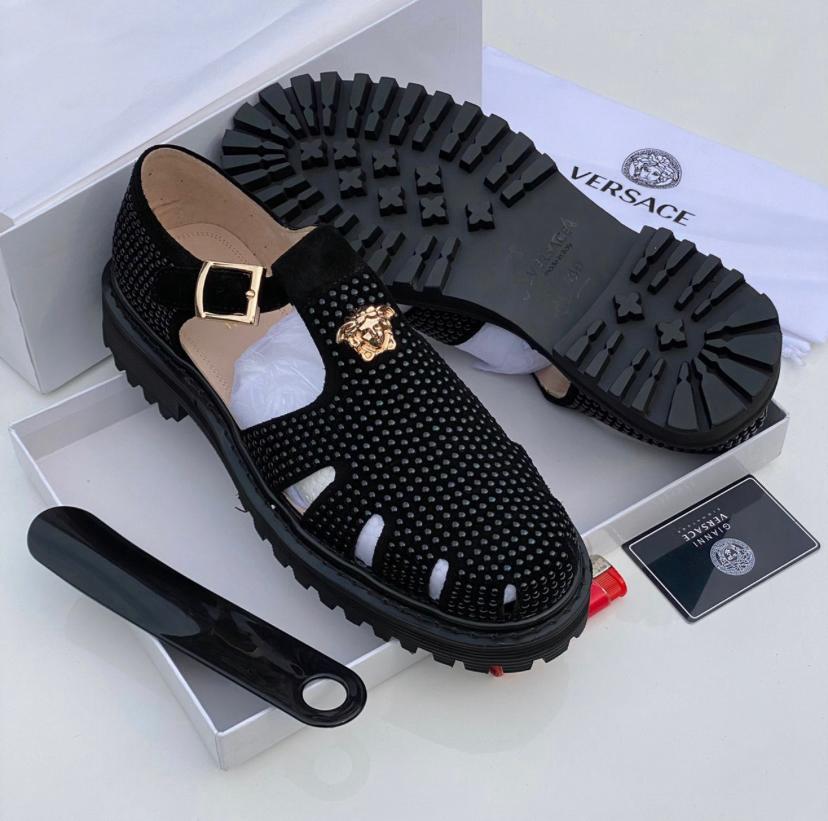 Authentic Versace fisherman sandals Versace men's black leather fisherman sandals with gold Medusa buckle and chunky black rubber lug sole, displayed with white Versace box, dust bag, and authenticity card.