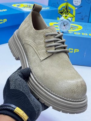FDCP men's sage green distressed suede chunky boots with rope laces and thick ridged platform sole, displayed with blue branded shoebox and vintage alarm clock on white surface.
