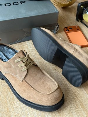 FDCP men's beige suede derby shoes with tonal laces and thick black rubber sole, displayed on wooden surface with grey branded shoebox and orange phone.