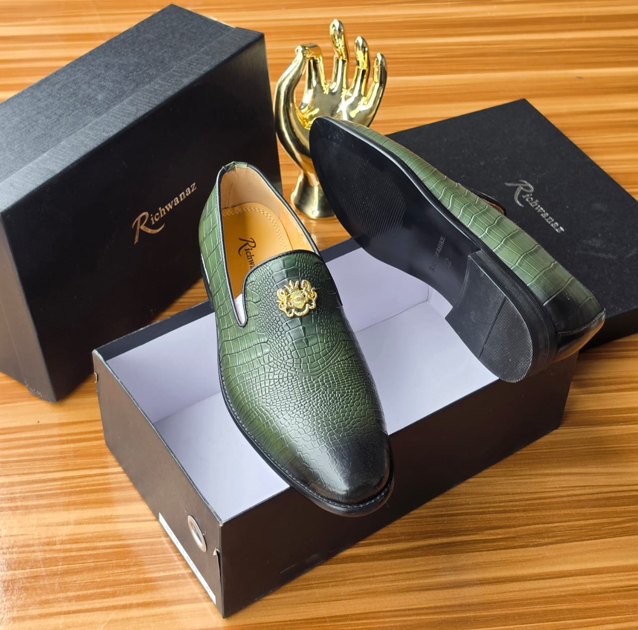 Richwanaz Bold green crocodile-embossed loafers ROLE You are a luxury e-commerce copywriter and conversion strategist for Swingdot Luxe, a Nigerian men’s footwear brand that sells 100% original global footwear brands (Nike, Adidas, Clarks, Timberland, etc.). All products are sourced from verified international suppliers and sold to Nigerian men who care deeply about authenticity, durability, and buying without regret. You understand Nigerian buyer psychology at an expert level. write product description, short description 3 lines max, alt text, tag. Using this format below write for the attached shoe. Upgrade your everyday style with these exquisitely crafted men’s luxury suede sneakers. Designed for the discerning gentleman who values both comfort and refined aesthetics, these shoes offer a seamless blend of premium materials and timeless design. The upper is fashioned from supple, premium-grade suede, providing a soft, luxurious feel and a sophisticated, textured finish. The clean contrast of the crisp white laces, toe cap, and ridged sole creates a classic, versatile look that pairs effortlessly with any outfit. The cushioned footbed and durable sole provide all-day comfort and stability, making them ideal for extended wear during daily commutes or weekend outings. These sneakers are more than just footwear; they are a statement of understated elegance. Pair them effortlessly with chinos and a button-down shirt for a polished smart-casual look, or with dark jeans for a relaxed yet refined ensemble. They are the essential accessory for the man who appreciates quality craftsmanship and timeless style. Key Features / Specifications Material: Premium-grade suede upper with durable textile accents. Sole: Thick, cushioned rubber sole with a classic ridged tread for comfort and grip. Fit: True-to-size with a roomy toe box for all-day wearability. Usage: Ideal for smart casual events, office wear (casual Fridays), weekend outings, and everyday wear. Why settle for less when you deserve the best? Don’t wait for the perfect occasion. This is your everyday power move. Your non-negotiable standard. Your statement of arrival. Click “BUY NOW” — because true luxury doesn’t wait, and neither should you. Limited availability. Authentic. Zero regrets.