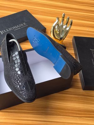 Men's luxury dark brown Billionaire Italian Couture loafers with embossed medallion pattern and blue soles resting on black branded shoeboxes.