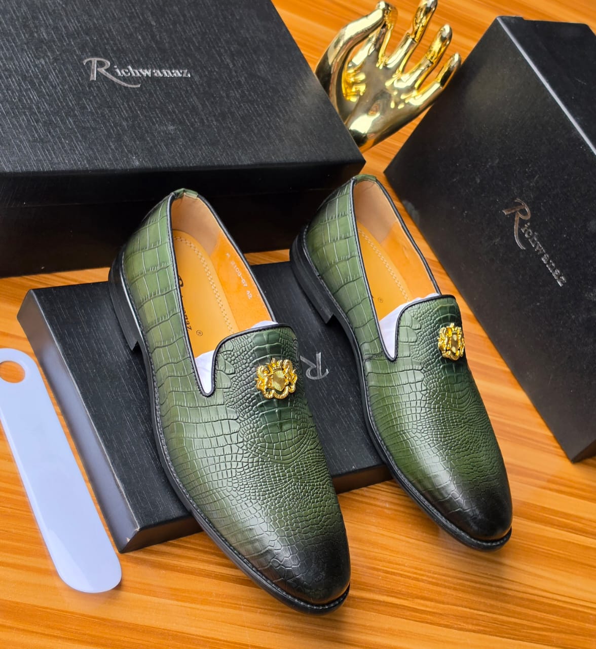 Richwanaz Bold green crocodile-embossed loafers ROLE You are a luxury e-commerce copywriter and conversion strategist for Swingdot Luxe, a Nigerian men’s footwear brand that sells 100% original global footwear brands (Nike, Adidas, Clarks, Timberland, etc.). All products are sourced from verified international suppliers and sold to Nigerian men who care deeply about authenticity, durability, and buying without regret. You understand Nigerian buyer psychology at an expert level. write product description, short description 3 lines max, alt text, tag. Using this format below write for the attached shoe. Upgrade your everyday style with these exquisitely crafted men’s luxury suede sneakers. Designed for the discerning gentleman who values both comfort and refined aesthetics, these shoes offer a seamless blend of premium materials and timeless design. The upper is fashioned from supple, premium-grade suede, providing a soft, luxurious feel and a sophisticated, textured finish. The clean contrast of the crisp white laces, toe cap, and ridged sole creates a classic, versatile look that pairs effortlessly with any outfit. The cushioned footbed and durable sole provide all-day comfort and stability, making them ideal for extended wear during daily commutes or weekend outings. These sneakers are more than just footwear; they are a statement of understated elegance. Pair them effortlessly with chinos and a button-down shirt for a polished smart-casual look, or with dark jeans for a relaxed yet refined ensemble. They are the essential accessory for the man who appreciates quality craftsmanship and timeless style. Key Features / Specifications Material: Premium-grade suede upper with durable textile accents. Sole: Thick, cushioned rubber sole with a classic ridged tread for comfort and grip. Fit: True-to-size with a roomy toe box for all-day wearability. Usage: Ideal for smart casual events, office wear (casual Fridays), weekend outings, and everyday wear. Why settle for less when you deserve the best? Don’t wait for the perfect occasion. This is your everyday power move. Your non-negotiable standard. Your statement of arrival. Click “BUY NOW” — because true luxury doesn’t wait, and neither should you. Limited availability. Authentic. Zero regrets.