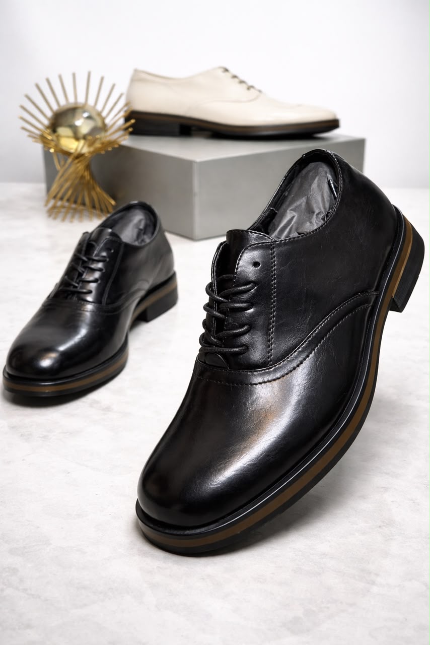 Men's luxury leather oxford shoe Men's luxury black leather oxford dress shoes with a thick sole and tan midsole accent resting on a marble surface.